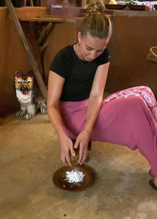 Grating fresh coconut during a village cooking class